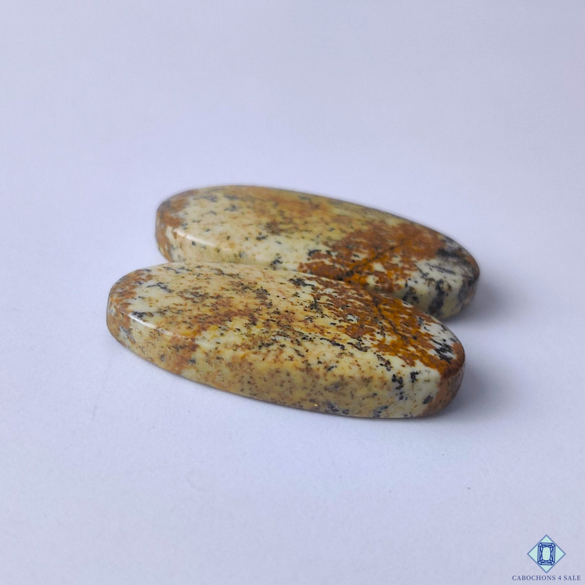 cabochons4sale, polished brown picture jasper oval cabochons showcasing distinctive landscape-inspired patterns and organic gemstone texture held between fingers