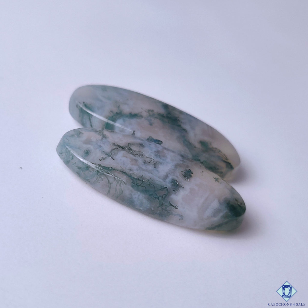cabochons4sale, polished oval moss agate cabochons in fresh green tones featuring intricate dendritic inclusions and unique mineral textures held between fingers