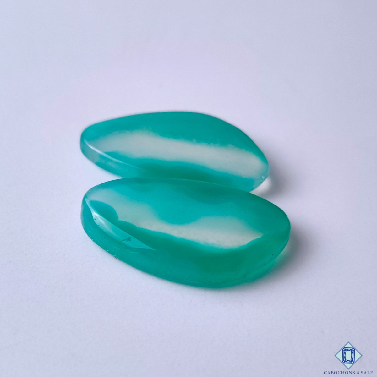 cabochons4sale, natural fancy green banded agate cabochons showcasing curved mineral lines, subtle color variation and distinctive polished stone character held between fingers