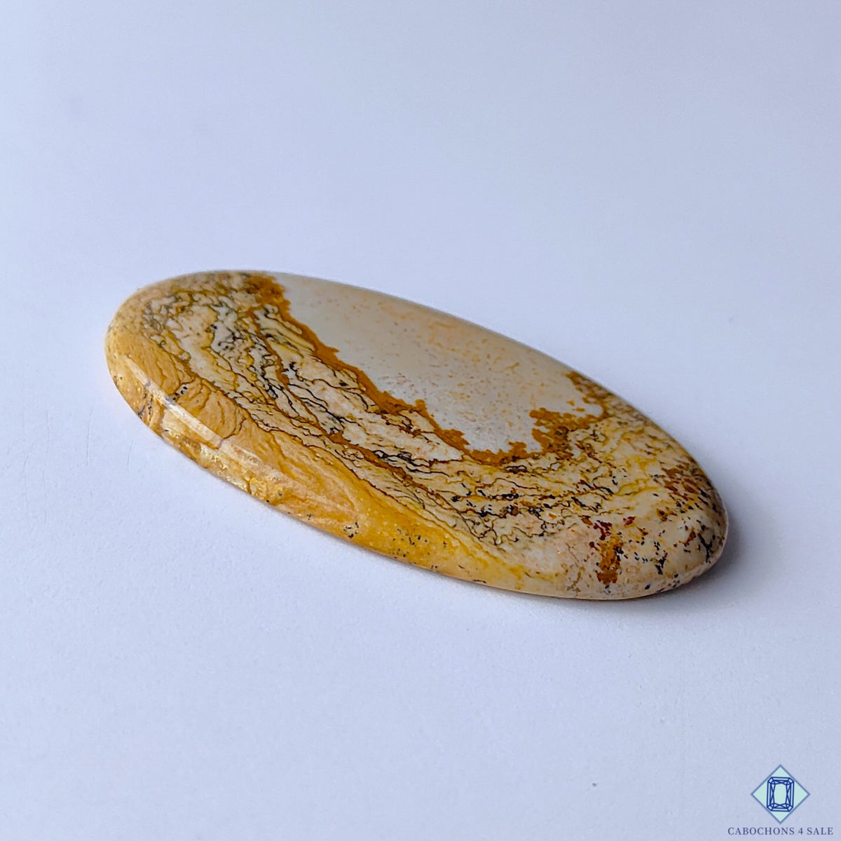 cabochons4sale, polished picture jasper oval cabochons featuring golden yellow and brown flowing patterns, distinctive scenic formations and natural stone character held between fingers