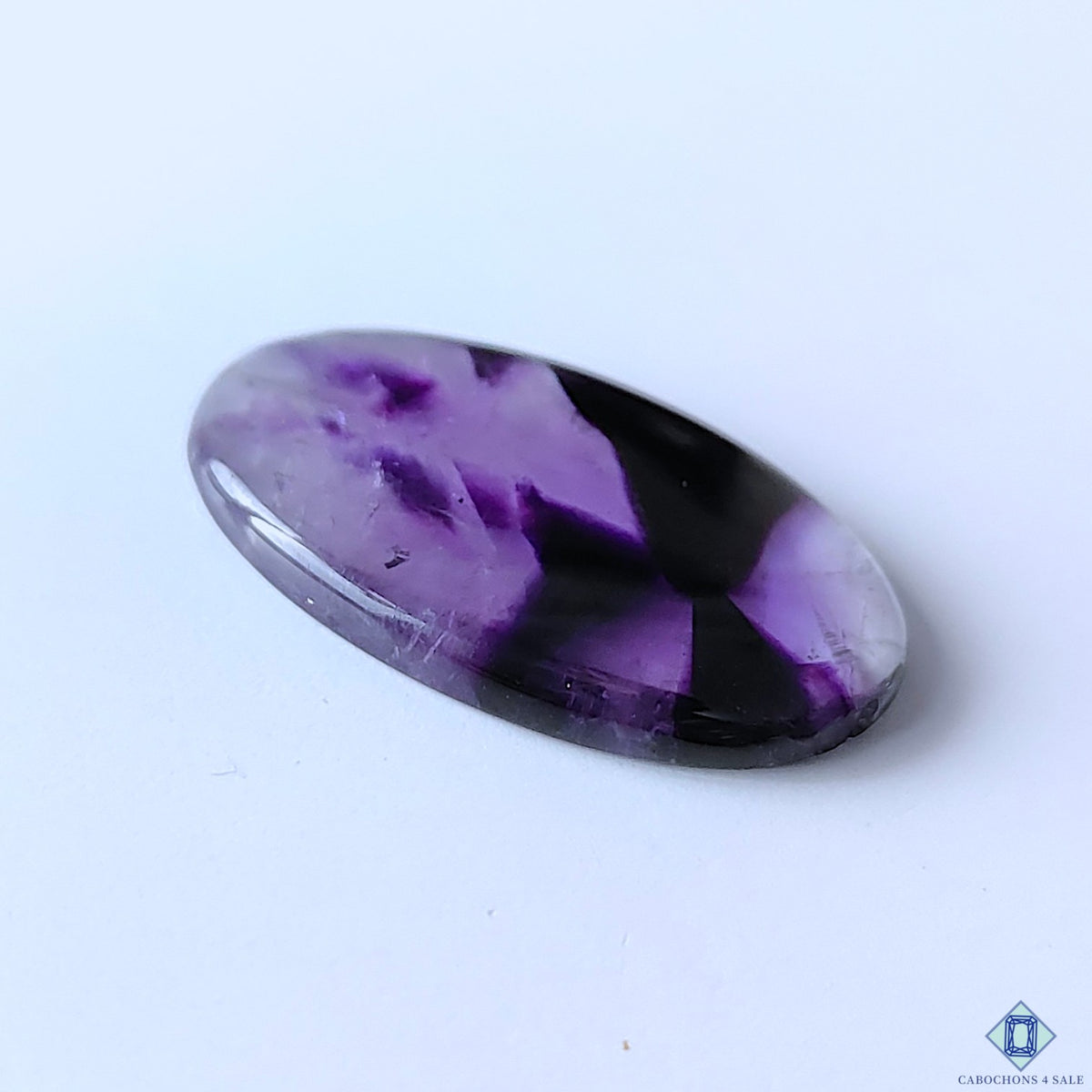 cabochons4sale, polished oval trapiche amethyst cabochons featuring elegant purple coloration, unique star-like zoning and natural crystalline character held between fingers