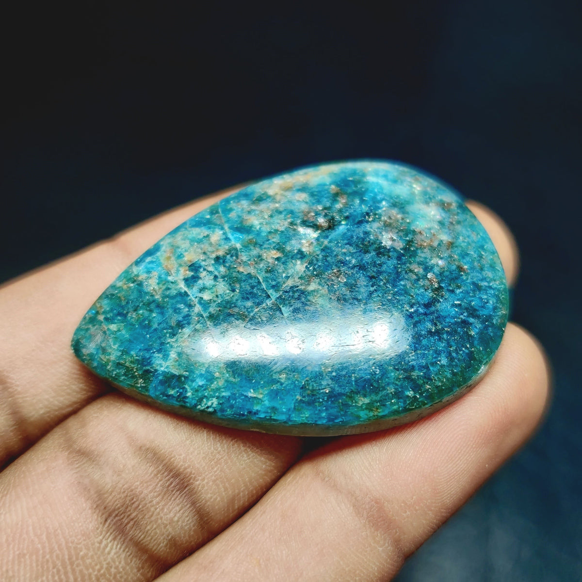 Cabochons4sale natural pear-shaped translucent green apatite gemstone held in a hand