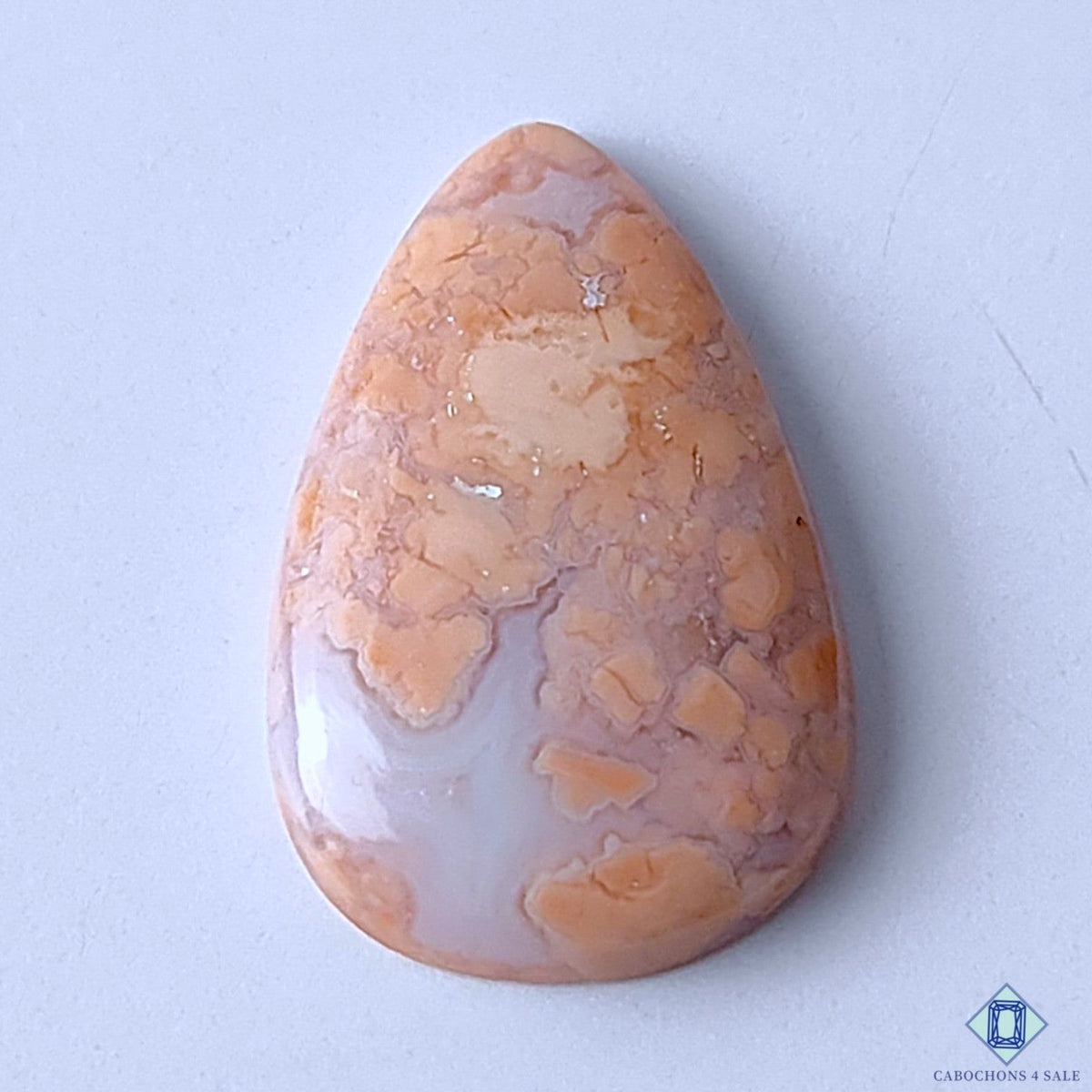Cabochons4sale pear-shaped opaque cotton candy agate gemstone with orange and white mottled patterns.