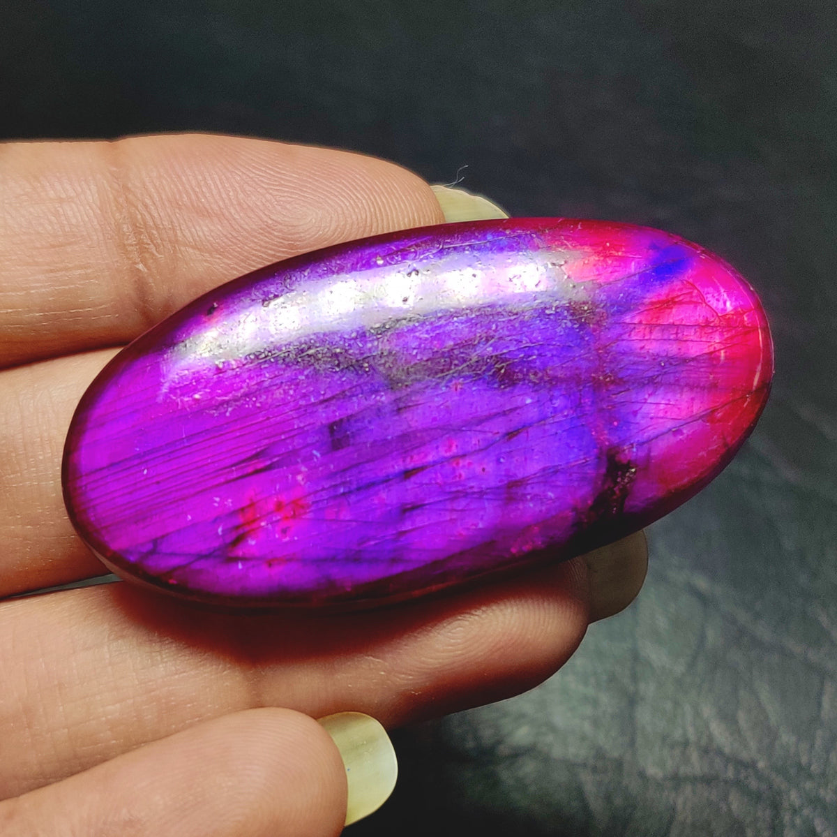 Cabochons4sale oval dyed purple labradorite cabochon gemstone with translucent finish held in hand