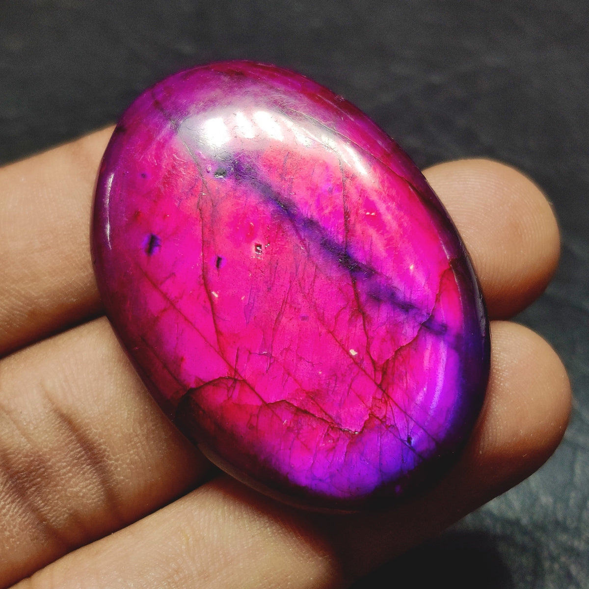 Cabochons4sale purple dyed labradorite oval cabochon gemstone with translucent finish held in a hand