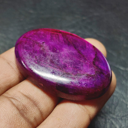 Cabochons4sale purple dyed labradorite oval cabochon gemstone with a translucent finish held in a hand