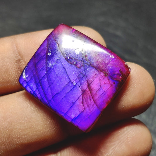 Cabochons4sale square purple dyed labradorite cabochon gemstone with translucent finish held between fingers