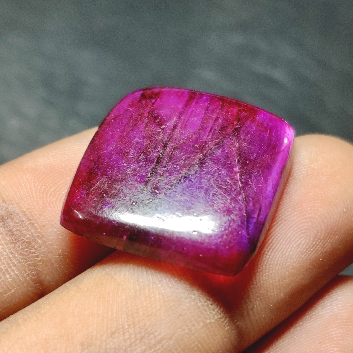 Cabochons4sale square purple dyed labradorite cabochon gemstone with a translucent finish held in fingers