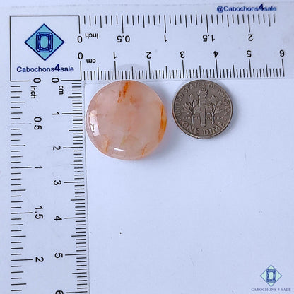 Cabochons4sale round translucent red fire quartz cabochon gemstone measuring 23x7mm next to a US dime for scale