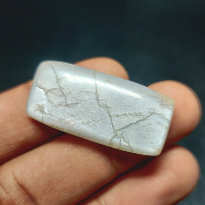 Cabochons4sale natural translucent grey moonstone rectangle cabochon held between fingers