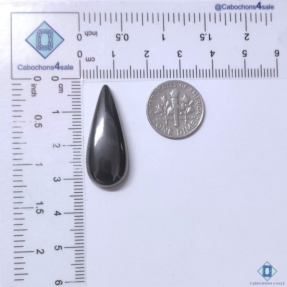 Cabochons4sale grey opaque gun metal pear cabochon gemstone measuring 31x12x6mm next to a US dime for scale