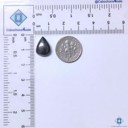 Cabochons4sale grey gun metal pear cabochon gemstone measuring 13x10x4mm next to a US dime for scale.