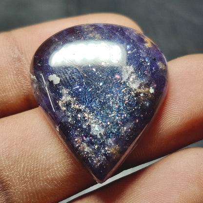 Cabochons4sale pear-shaped translucent blue iolite cabochon gemstone with natural sparkling inclusions held in hand