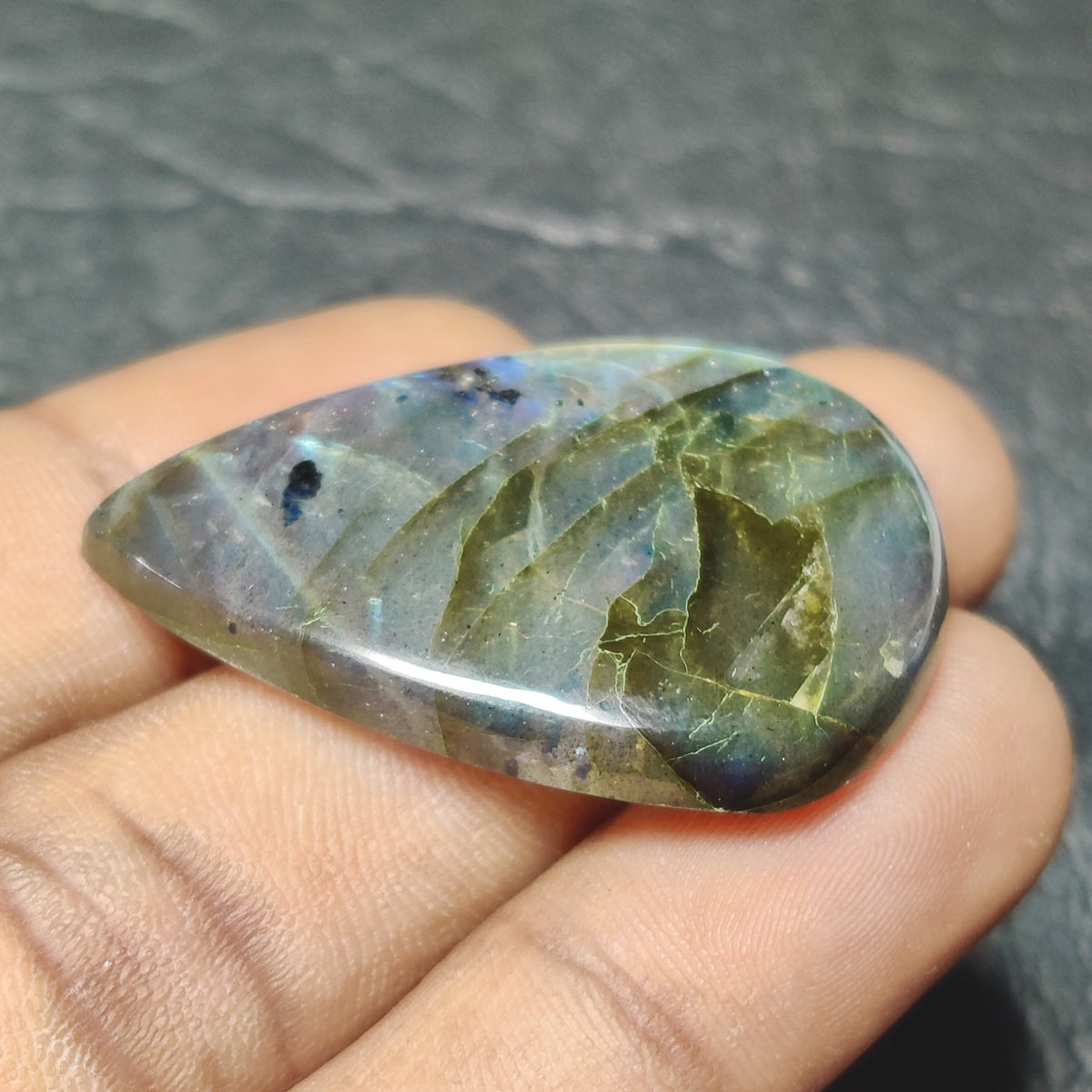 Cabochons4sale translucent pear-shaped labradorite gemstone with natural multi-colour iridescent flashes held in hand