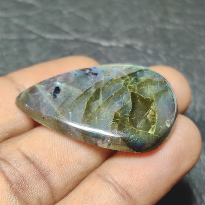 Cabochons4sale translucent pear-shaped labradorite gemstone with natural multi-colour iridescent flashes held in hand