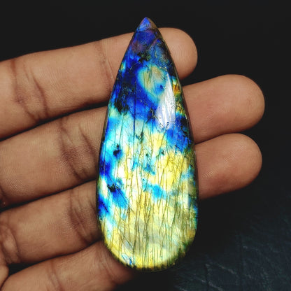 Cabochons4sale pear-shaped labradorite cabochon with vibrant blue and yellow iridescent flashes held in a hand