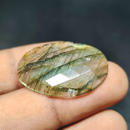 Cabochons4sale oval rose cut labradorite gemstone with translucent multi-colour flashes held between fingers