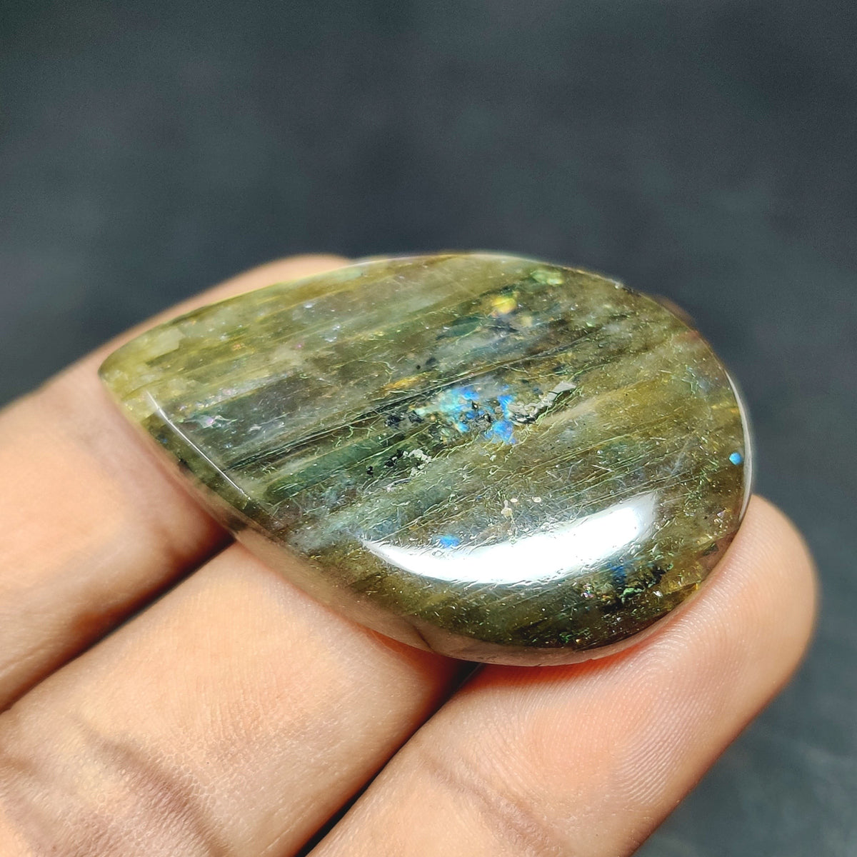 Cabochons4sale pear-shaped translucent labradorite gemstone with natural multi-colour flashes held in hand