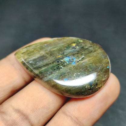 Cabochons4sale pear-shaped translucent labradorite gemstone with natural multi-colour flashes held in hand