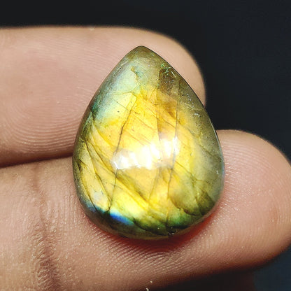 Cabochons4sale pear-shaped translucent yellow labradorite gemstone cabochon held between fingers
