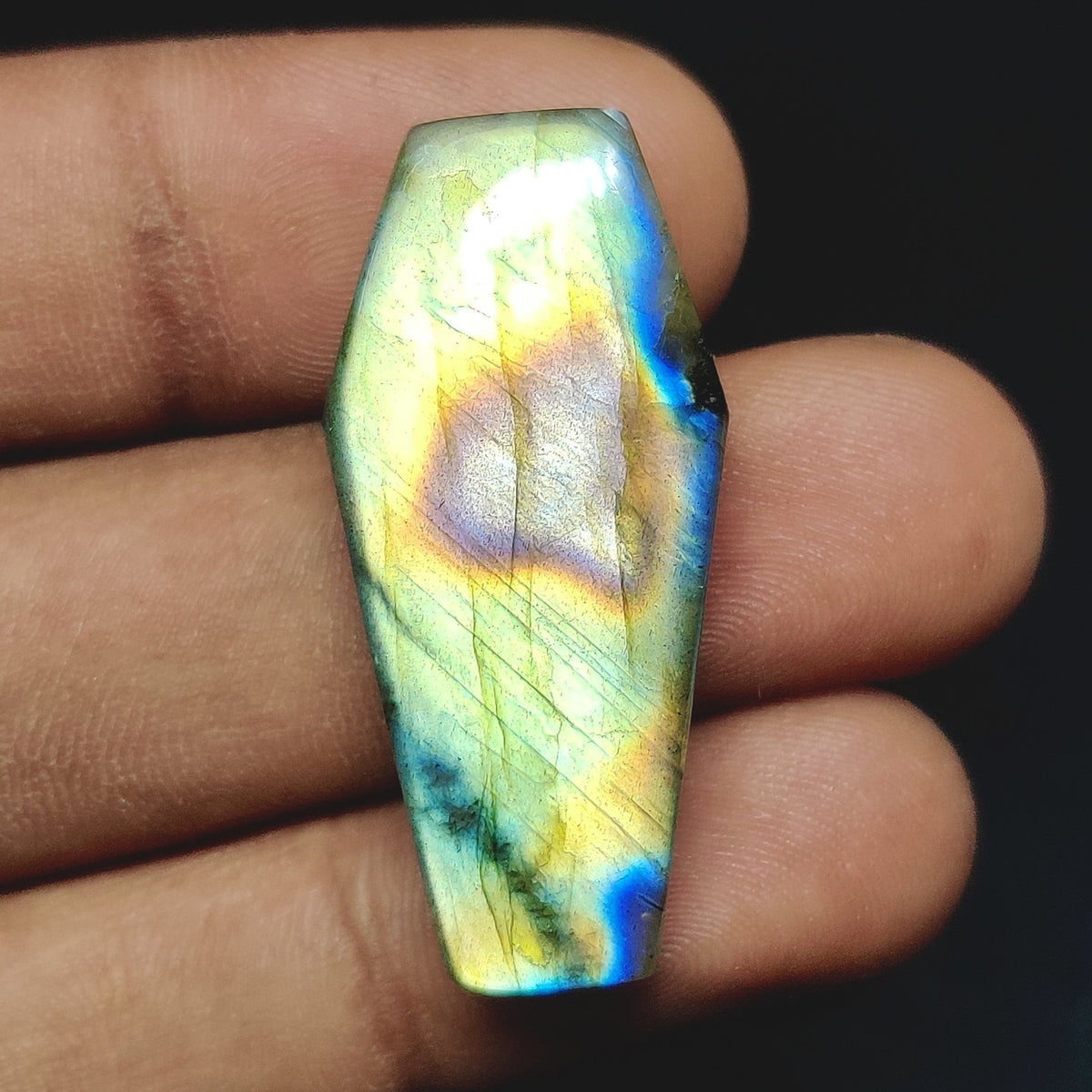 Cabochons4sale natural translucent labradorite fancy cabochon with iridescent blue and yellow flash held in hand