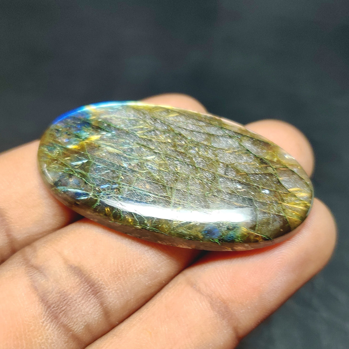 Cabochons4sale oval labradorite cabochon with translucent multi-colour flashes held in a hand