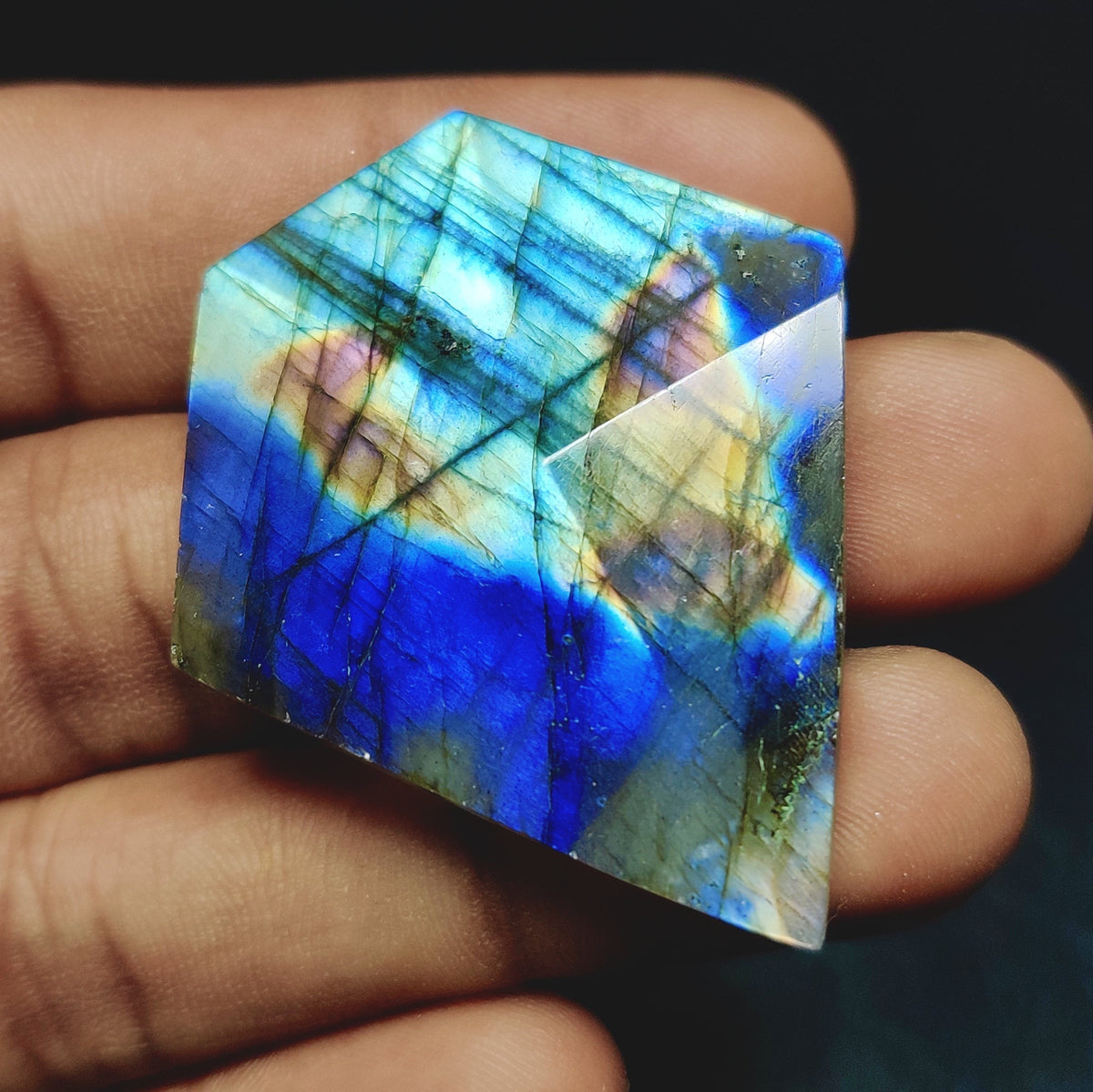 Cabochons4sale fancy labradorite cabochon with vibrant blue and gold iridescent flash held in a hand