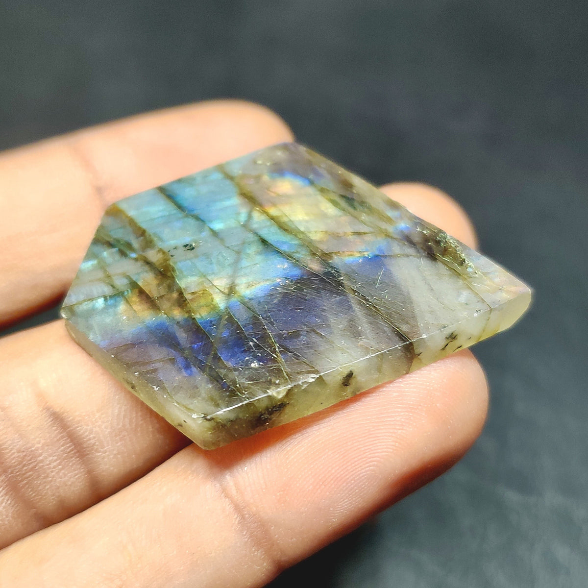 Cabochons4sale fancy labradorite cabochon with translucent multi-colour iridescent flash held in hand