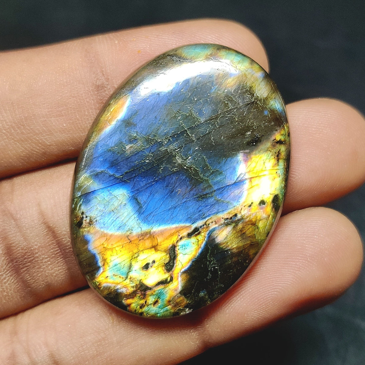 Cabochons4sale oval labradorite cabochon featuring vibrant blue and yellow iridescent flashes on a translucent stone