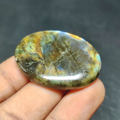 Cabochons4sale oval labradorite cabochon with iridescent multi-colour flashes held between fingers