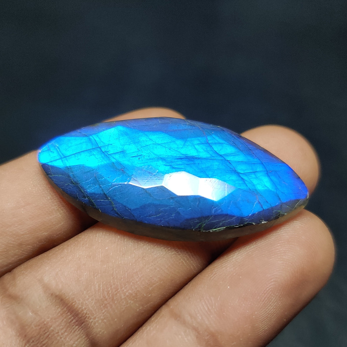 Cabochons4sale marquise-cut labradorite gemstone with a vibrant blue honeycomb facet pattern held in a hand