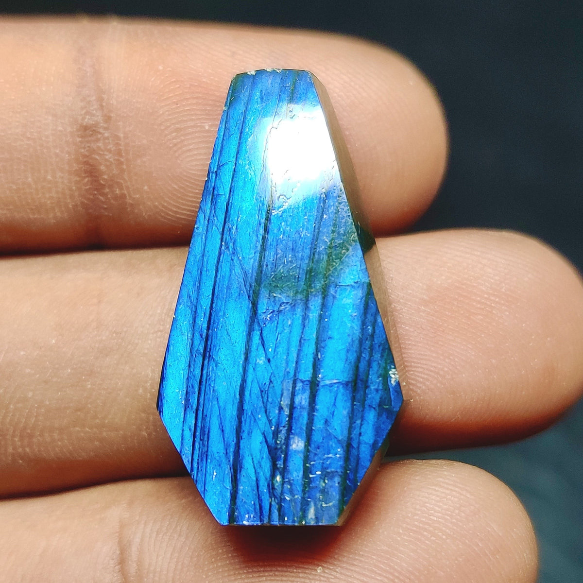 Cabochons4sale natural translucent blue labradorite fancy cabochon gemstone held between fingers