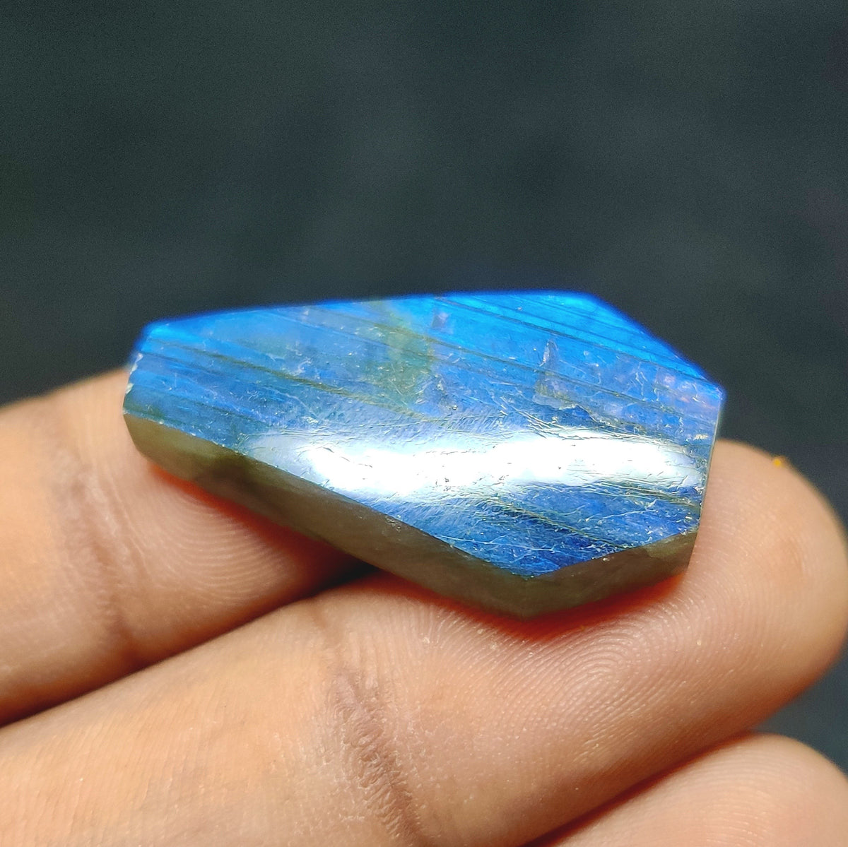 Cabochons4sale fancy translucent blue labradorite gemstone cabochon held between fingers