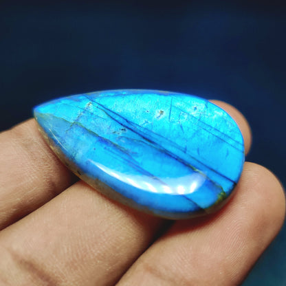 Cabochons4sale pear-shaped labradorite gemstone with vibrant blue flash and translucent finish held in hand