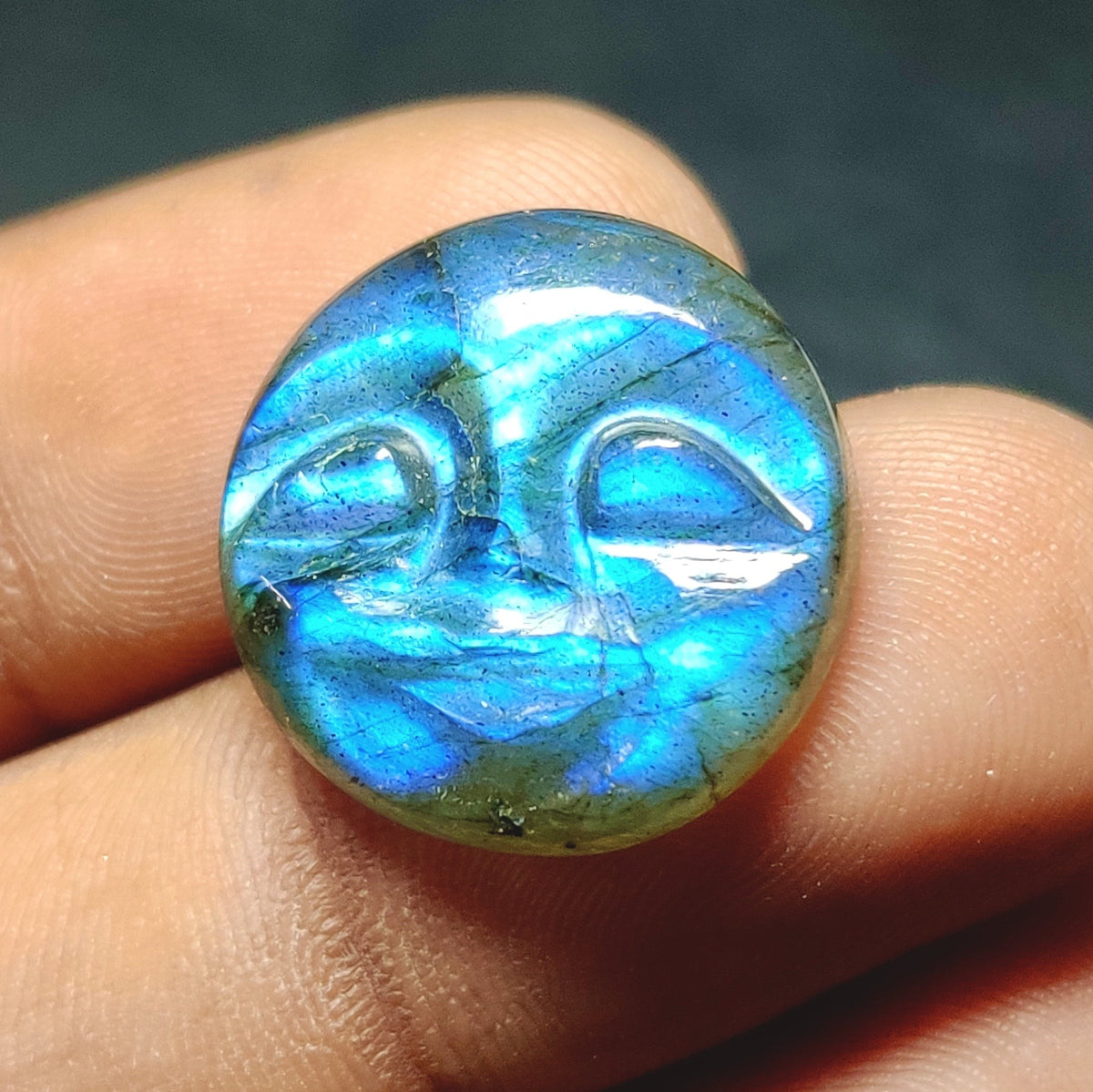 Cabochons4sale translucent blue labradorite gemstone carved into a round face cabochon held between fingers