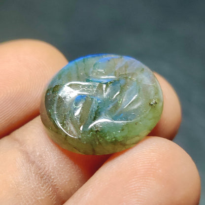 Cabochons4sale translucent blue labradorite gemstone carving held between fingers showing natural iridescent sheen