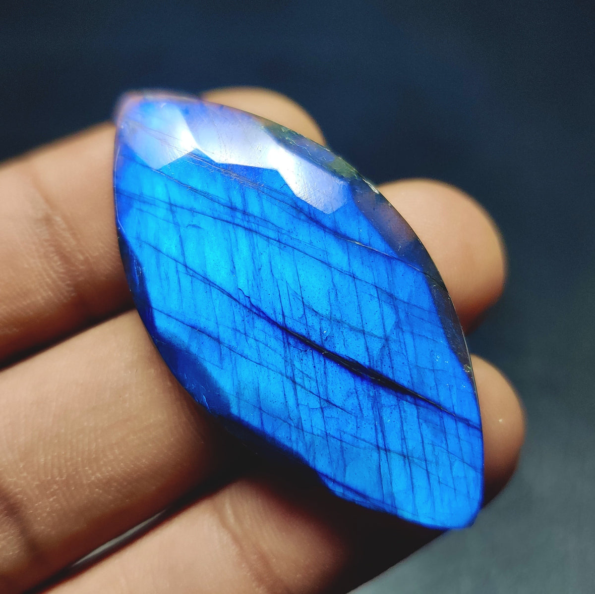 Cabochons4sale translucent marquise cut labradorite gemstone with vibrant blue flash held in hand