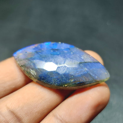 Cabochons4sale translucent blue marquise labradorite gemstone held in hand showing natural iridescent flash