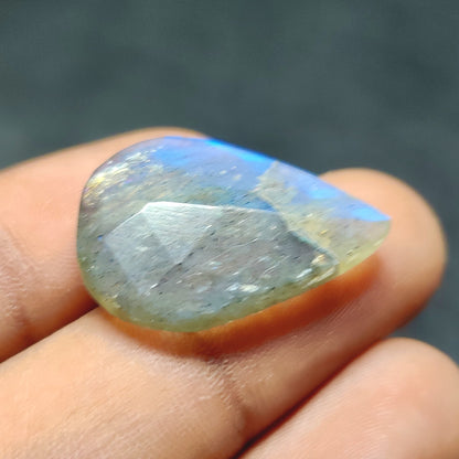 Cabochons4sale pear-shaped translucent labradorite gemstone with blue iridescent flash held between fingers