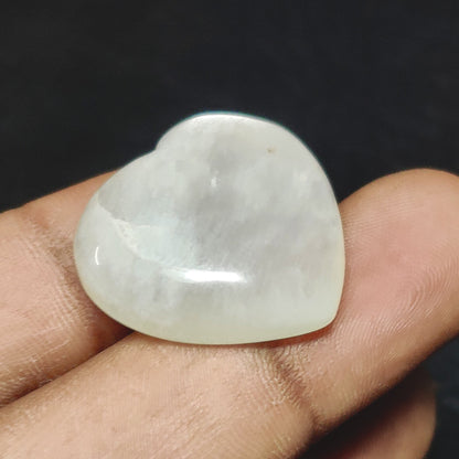 Cabochons4sale natural translucent white moonstone heart carving held between fingers