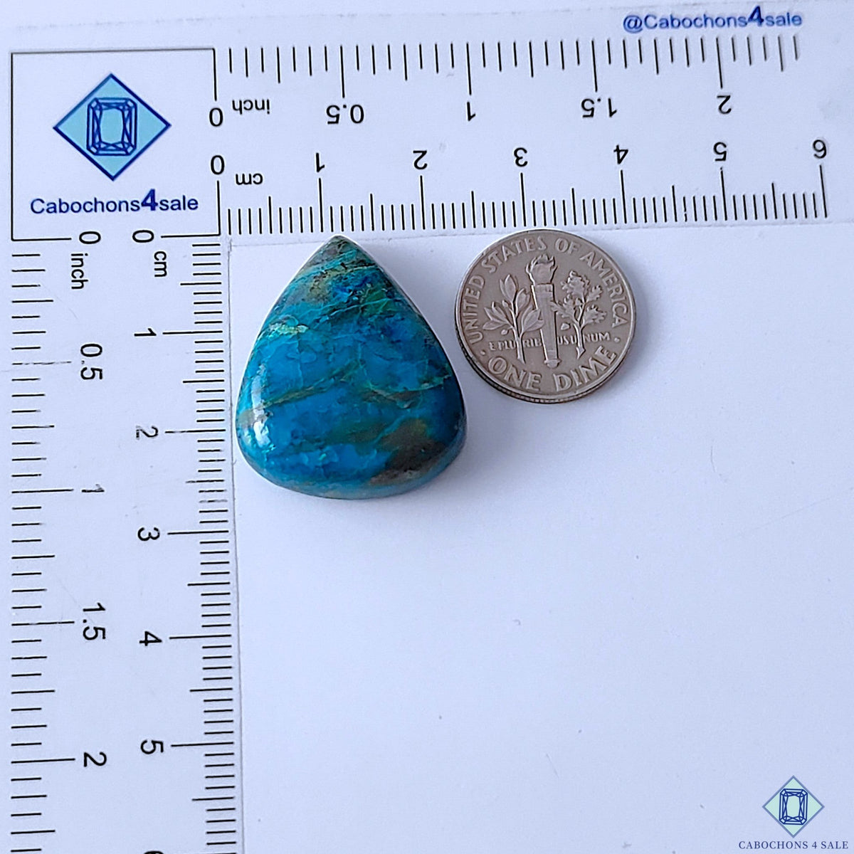 Cabochons4sale natural pear-shaped Quantum Quattro cabochon gemstone with blue and green patterns next to a US dime.