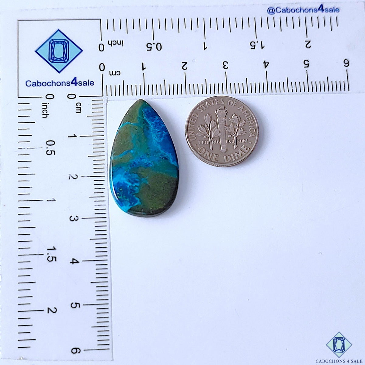 Cabochons4sale pear-shaped Quantum Quattro cabochon gemstone with blue and green patterns next to a US dime for scale.