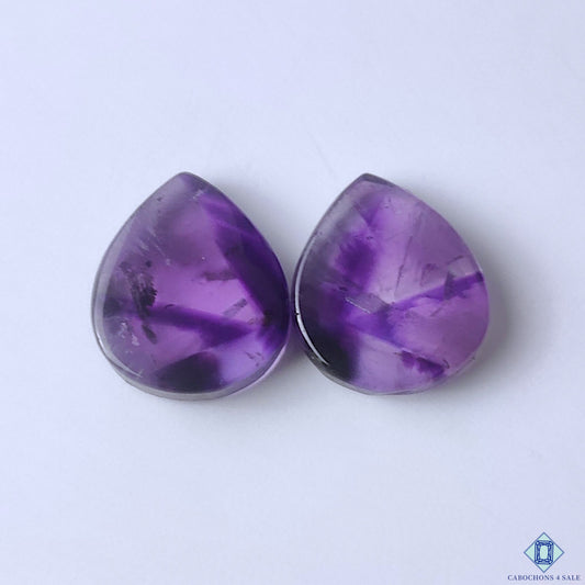 cabochons4sale, natural purple amethyst pear cabochons with rich violet color, subtle crystal texture and polished gemstone surfaces held between fingers