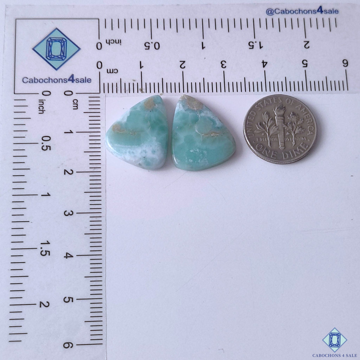 cabochons4sale, aqua blue larimar pear gemstone cabochons accented with creamy white mineral formations, flowing patterns and smooth stone texture held between fingers