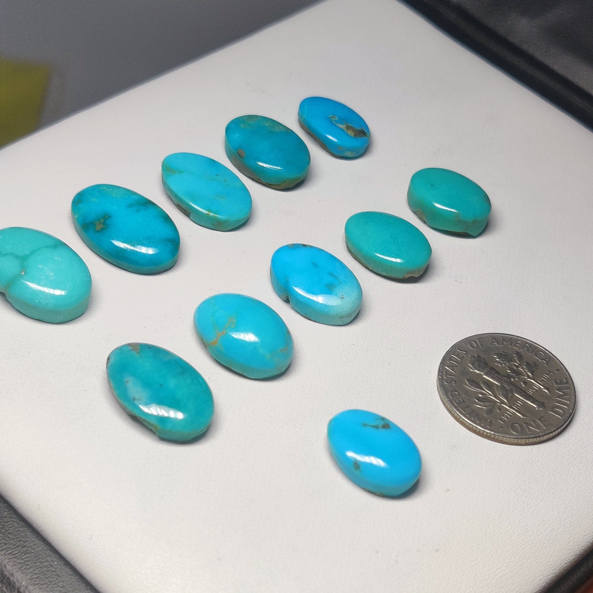 Cabochons4sale natural Arizona turquoise cabochons in oval shapes with blue-green hues and matrix, shown with a dime.