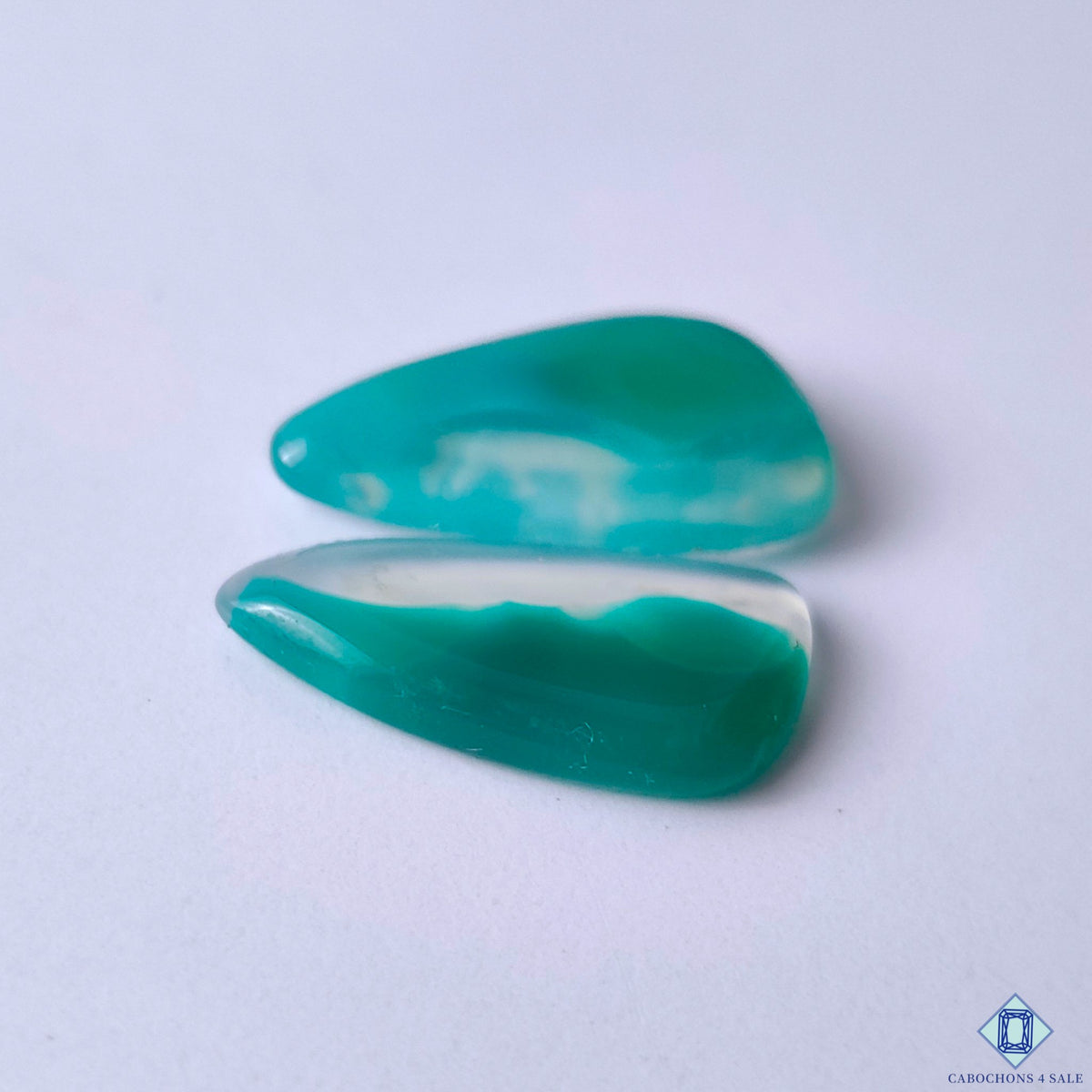 cabochons4sale, polished green banded agate fancy cabochons with contrasting white bands, flowing mineral layers and distinctive natural stone character held between fingers