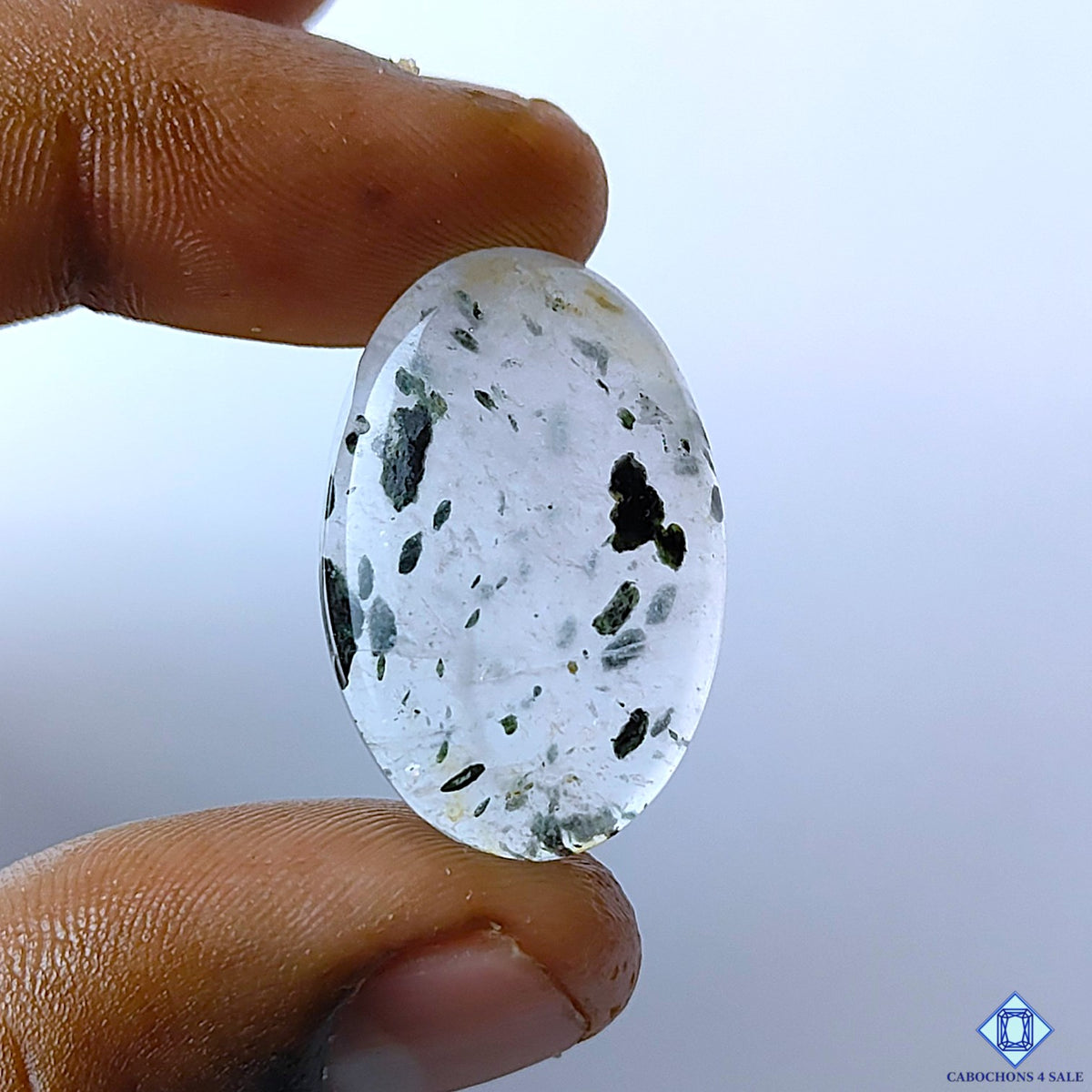 cabochons4sale, black dot quartz oval cabochons in white and black tones with striking dark dot inclusions, natural mineral patterns and polished surfaces held between fingers