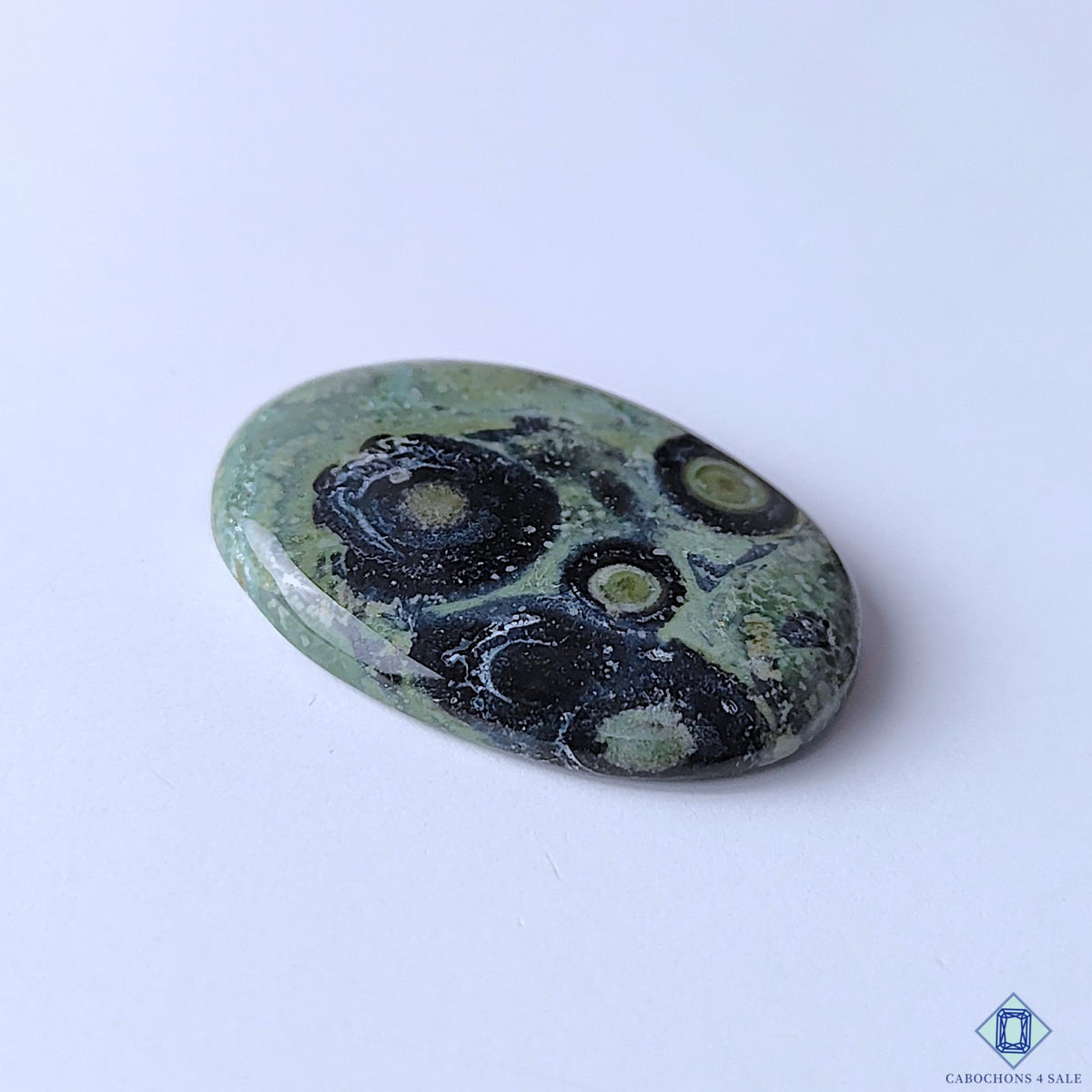 cabochons4sale, natural Kambaba Jasper oval cabochons featuring forest green color, bold black markings, intricate organic patterns and smooth stone surfaces held between fingers