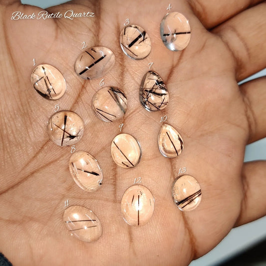 Cabochons4sale collection of natural black rutile quartz cabochons with needle-like inclusions held in a palm