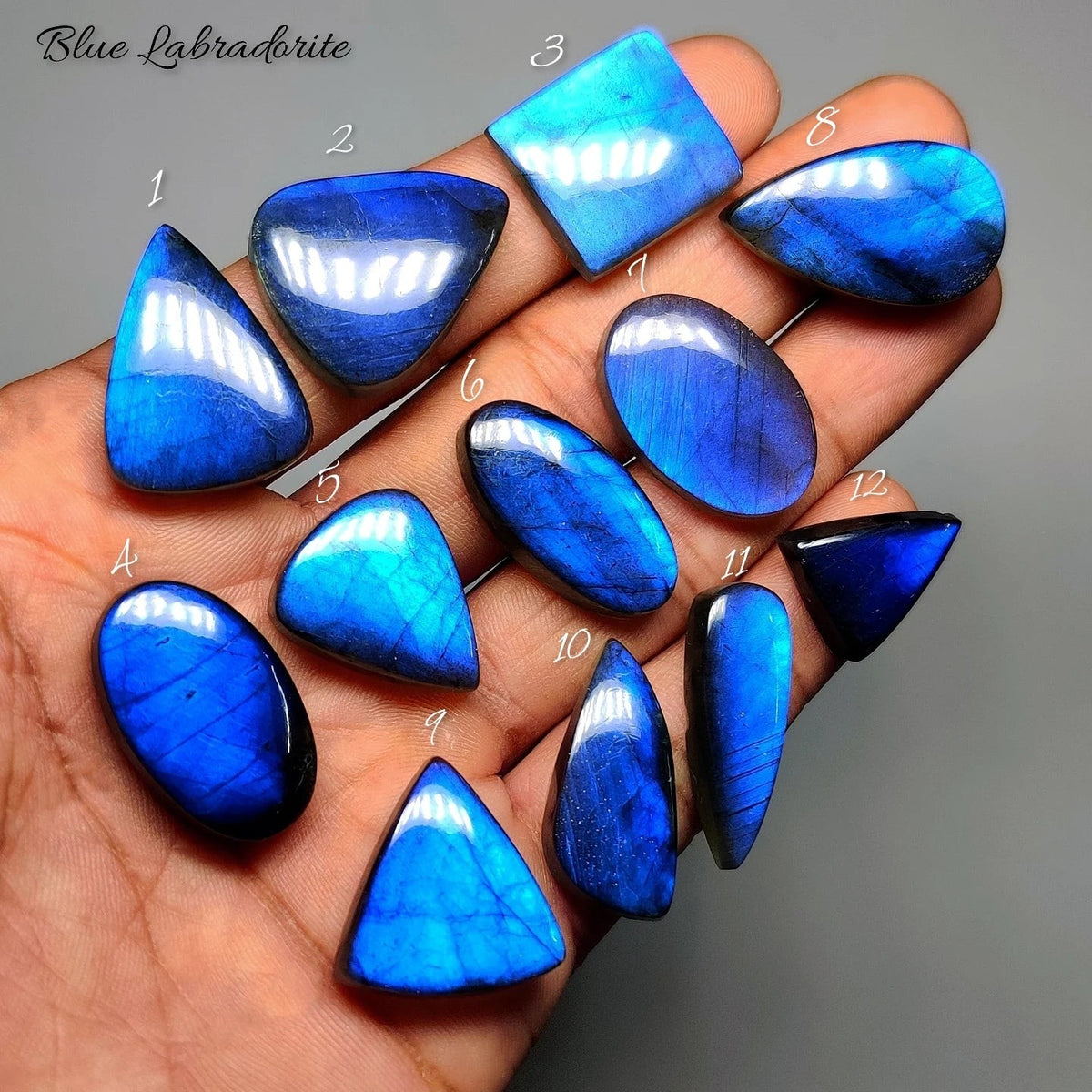 Cabochons4sale collection of polished natural blue labradorite gemstones with vibrant electric blue flash in hand